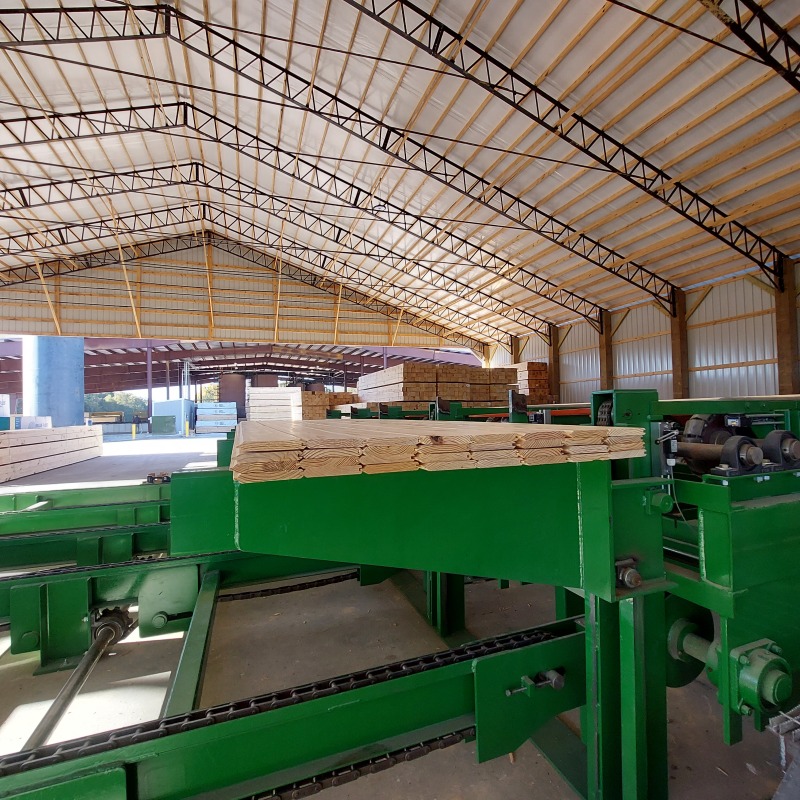 Person stacking with treated lumber.